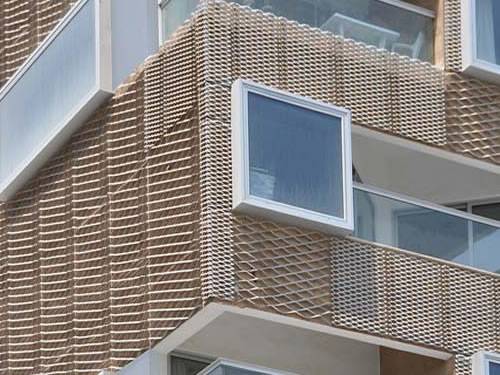 Brown aluminum expanded metal  meshes with diamond holes are installed on the facades of residential building.