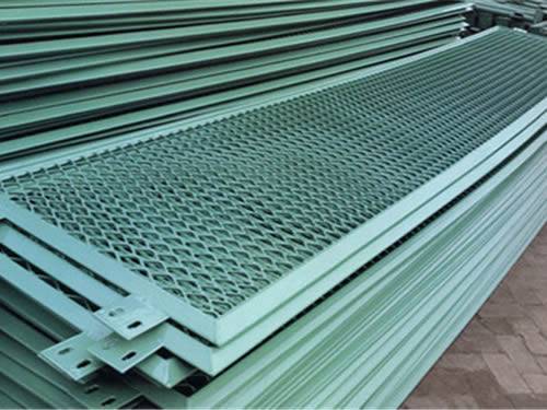  Many expanded metal grating panels with green surface and diamond holes are stacked together neatly.