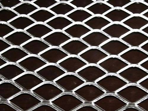 A piece of galvanized expanded metal steel sheet with diamond holes and sharp side.