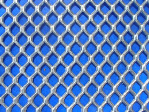 Heavy duty galvanized expanded metal sheet with flattened surface and hexagonal holes.