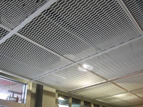 Expanded metal ceiling tiles with hexagonal holes are installed on the ceiling at home.