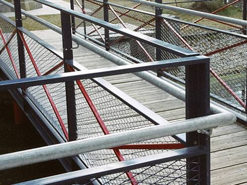 Expanded metal infill panels with diamond holes are installed on the both sides of walkway.